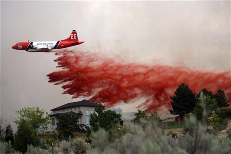 A tanker plane drops fire retardant on homes near Eagle, Idaho, on Wednesday.